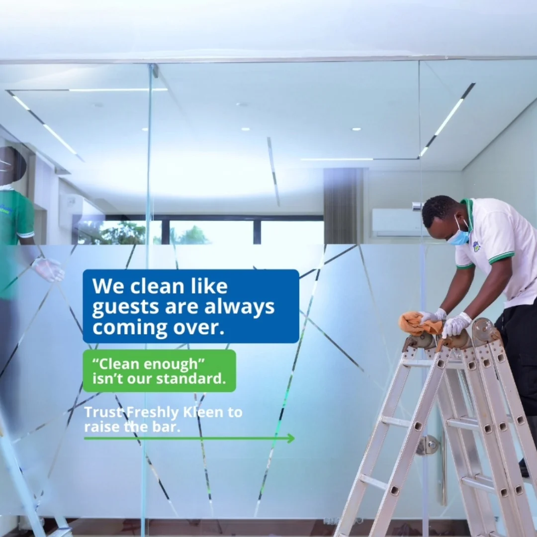 Staff cleaning interior glass of office space.